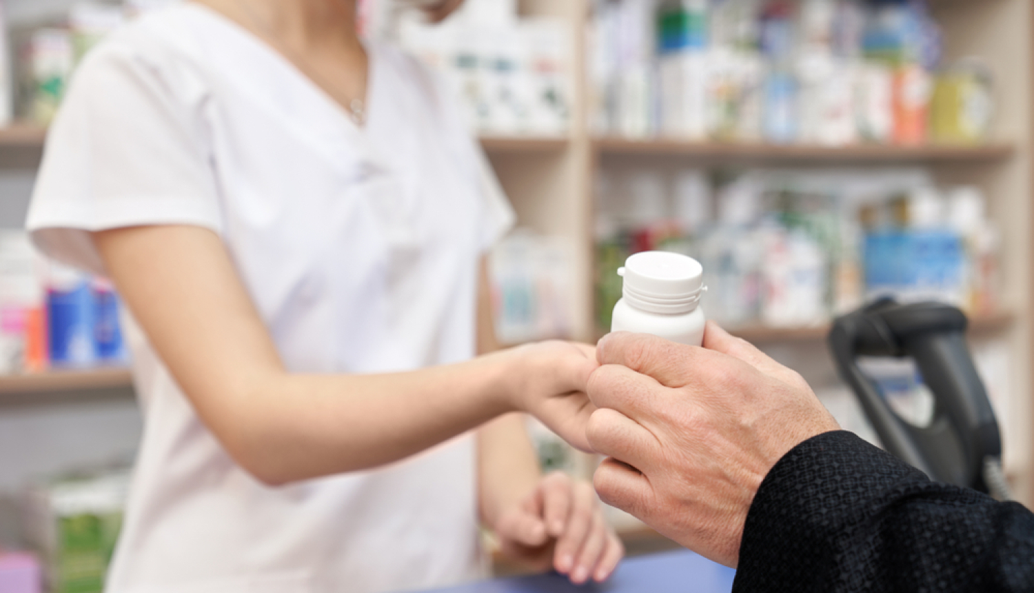 Aptiekā farmaceite pasniedz cilvēkam  medikamentus