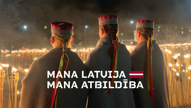 Trīs jaunas sievietes latviešu tautastērpos stāv pie pretī iedegtām lapām. Uz attēla sauklis - Mana Latvija, mana atbildība un Latvijas karoga grafisks atveids.