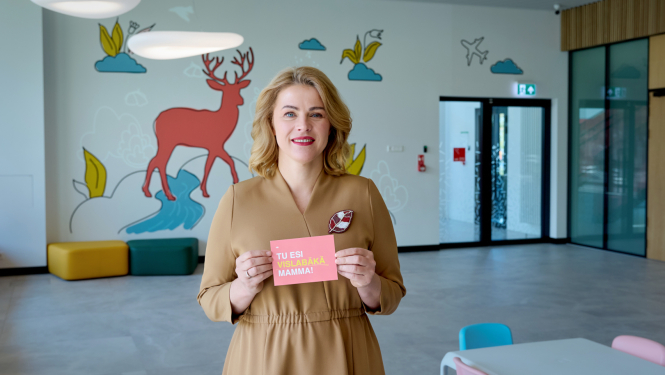 Ministru prezidente Evika Siliņa tur rokās kartīti ar uzrakstu "Tu esi vislabākā mamma!"