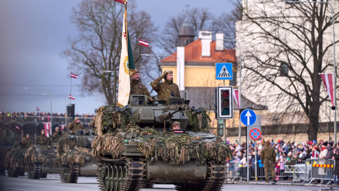 Latvijas armijas militārie transportlīdzeklī un karavīri piedalās militārajā parādē 11. novembra krastmalā