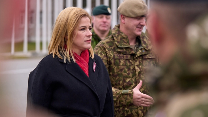 Ministru prezidente Evika Siliņa Ādažu militārajā bāzā, blakus premjerministrei militārpersonas. 