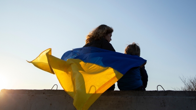 Sieviete ar bērnu un Ukrainas karogu