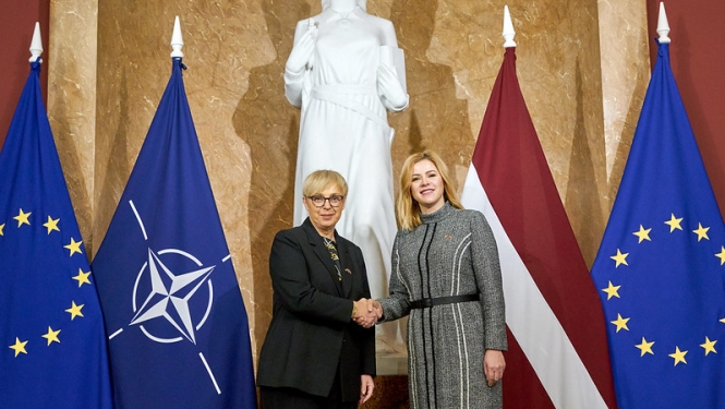 Ministru prezidente Evika Siliņa sasveicinās ar Slovēnijas prezidenti Natašu Pircu Musaru. Abas amatpersonas stāv 1.stāva vestibilā Ministru kabinetā. fonā ES,NATO, Latvijas karogi. 