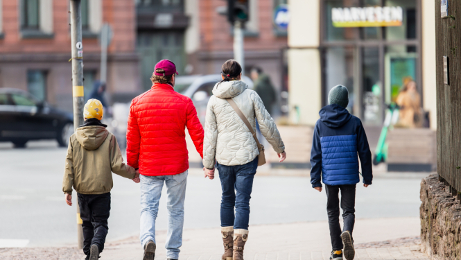 Ģimene - vecāki un divi dēli - iet pa ielu