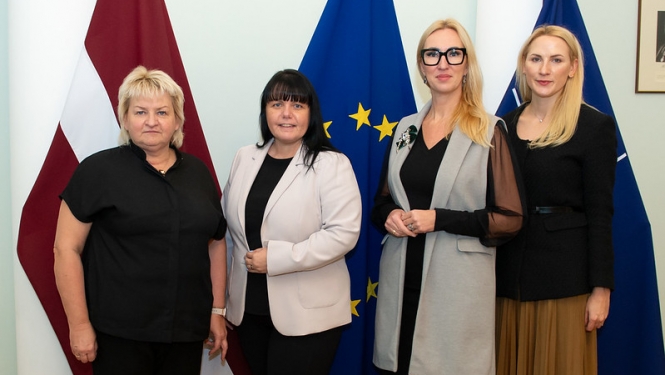 Tikšanās dalībnieces uz Latvijas, Eiropas Savienības un NATO karogu fona
