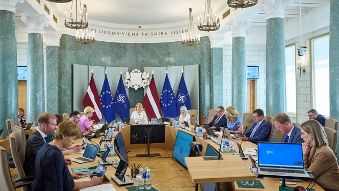 Ministru kabineta sēde. Ministri un Ministru prezidente sēž savās darba vietās pie sēžu galda. 