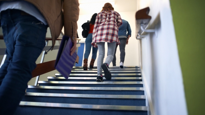 Skolēni skolā kāpj augšā pa kāpnēm