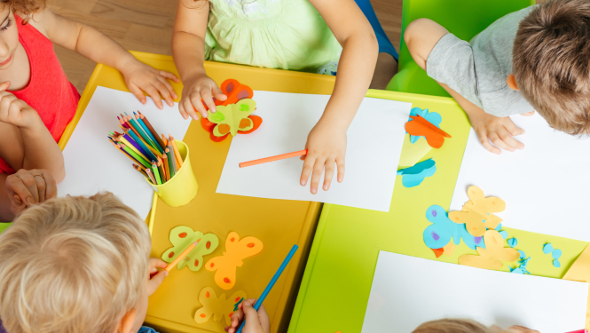 Foto ar bērnudāza galdu attēlojumu un bērnu rokdarbiem