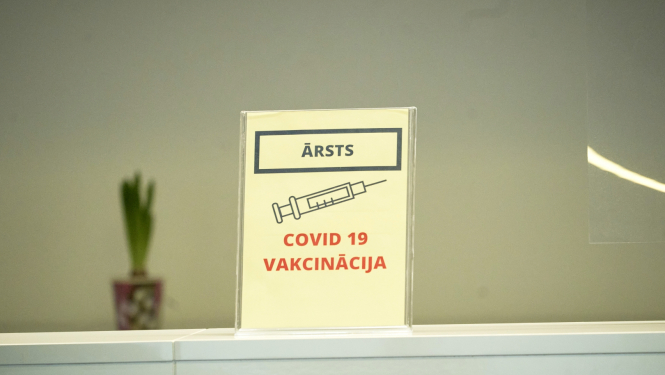attēls ar šļirci un uzrakstu Covid-19 vakcinācija