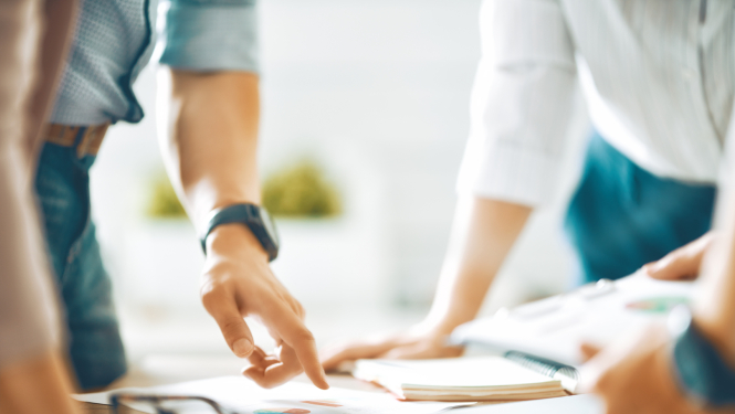 Ilustratīvs attēls ar cilvēku rokām un biroja darba virsmu