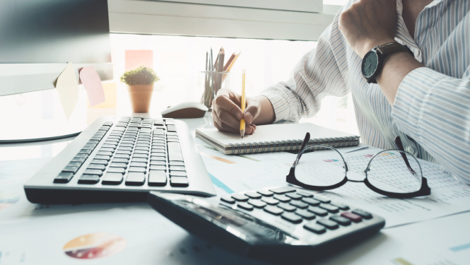 Fondu aprēķināšana, divi kalkulatori, lapas ar gafikiem un domājošs vīrietis