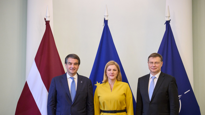 Fotogrāfijā pie Latvijas, Eiropas Savienības, NATO karogiem no labās Eiropas Komisijas priekšsēdētājas izpildvietnieks kohēzijas un reformu jautājumos Rafaēle Fito, Ministru prezidente Evika Siliņa, Eiropas Komisijas priekšsēdētājas izpildvietnieks jautājumos par ekonomiku Valdis Dombrovskis