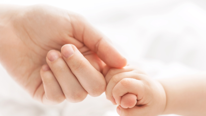 Māte tur sava jaundzimušā roku