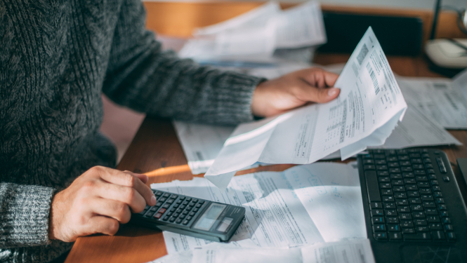 Vizualizācija, kurā persona uz kalkulatora rēķina izmaksu tabulas