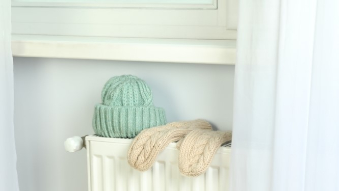 Uz radiatora žāvējas cepure un cimdi