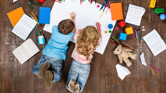 Bērni uz grīdas ar mantām zīmē