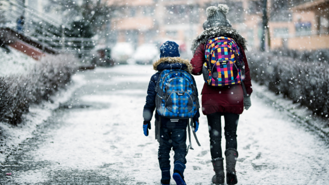 Bērni no mugurpuses ar mugursomām ziemā