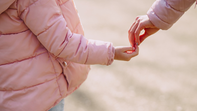 Bērns un vecāks sadodas rokās