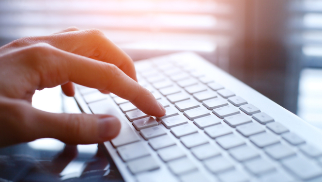 Sievietes roka uz datora klaviatūras