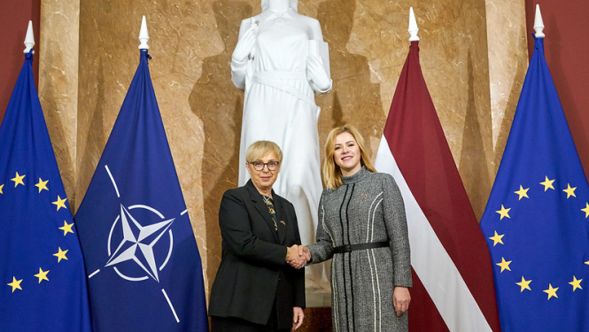 Ministru prezidente Evika Siliņa sasveicinās ar Slovēnijas prezidenti Natašu Pircu Musaru. Abas amatpersonas stāv 1.stāva vestibilā Ministru kabinetā. fonā ES,NATO, Latvijas karogi. 