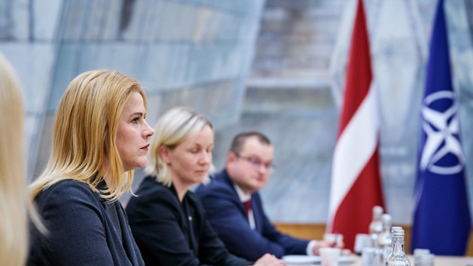 Ministru prezidente Evika Siliņa tikšanās laikā ar NATO amatpersonām. Fonā redzami Latvijas un NATO karogi