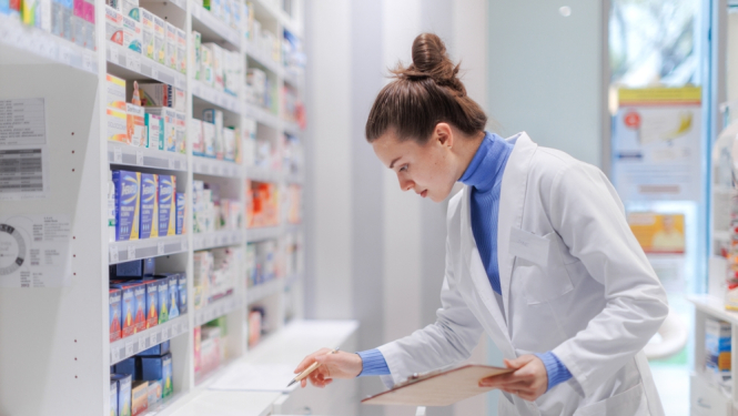 Farmaceite aptiekā ar medikamentiem fonā