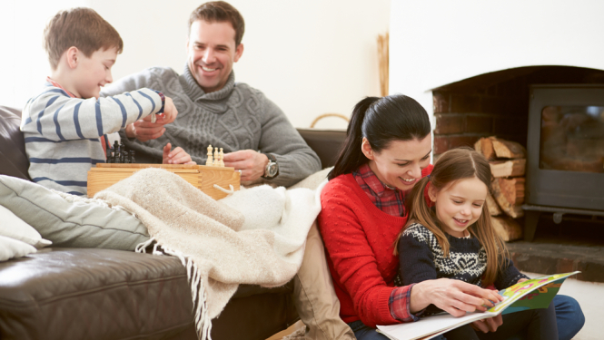 Ģimene kopīgi pavada laiku, fonā krāsns