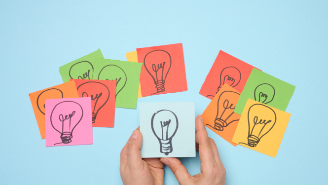 Uz dažādu krāsu papīra lapiņām uzzīmētas spuldzītes