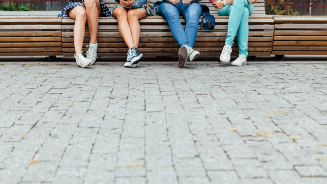 Jaunieši sēž uz soliņa