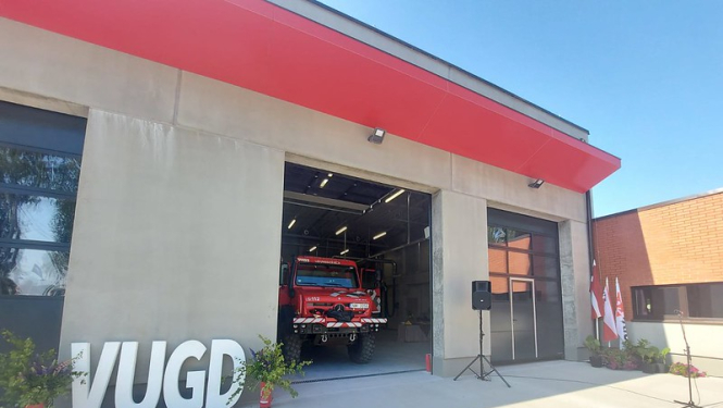 Fotogrāfija, kurā redzams Katastrofu pārvaldības centrs, ugunsdzēsēju auto un lieli burti VUGD.