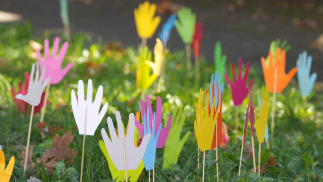 Zālē saspraustas bērnu veidotas rociņas no krāsaina papīra. Foto no KIVAS programmas atklāšanas pasākuma. 