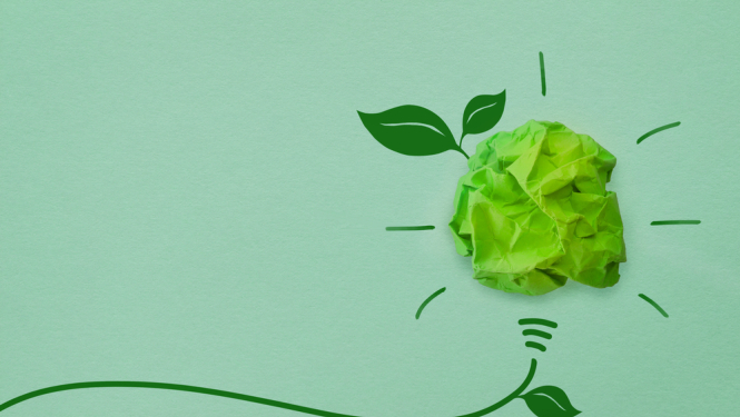 Zaļa papīra spuldze uz zaļa fona ar zaļām lapiņām. 