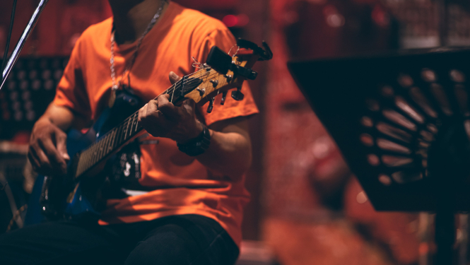 Vīrietis uz skatuves spēle ģitāru