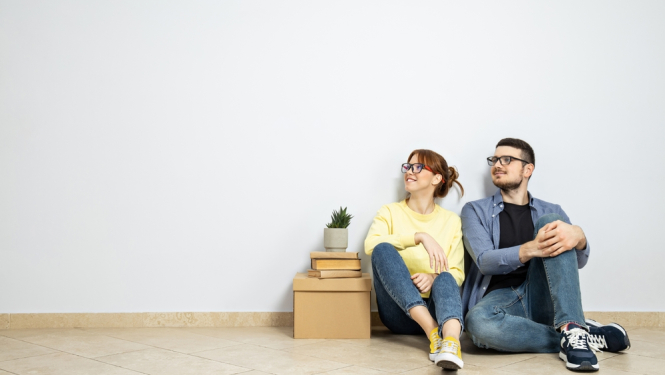 Jauns pāris sēž tikko ievācies jaunajā mājoklī