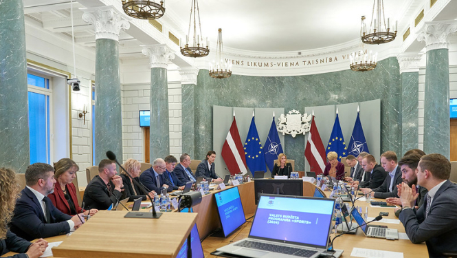 Ministru prezidente  vada Latvijas Nacionālā sporta padomi Ministru kabinetā. Ap galdu sēž visi padomes dalībnieki.