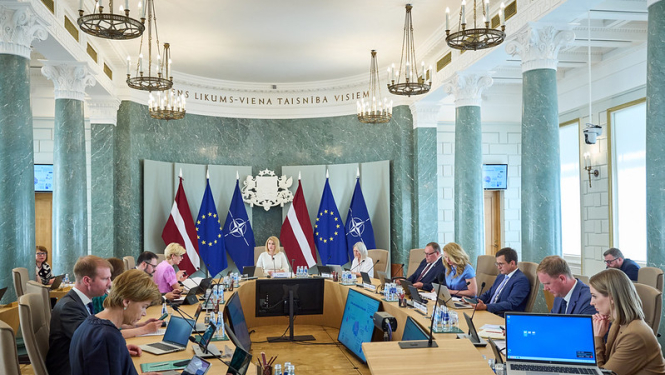 Ministru kabineta sēde. Ministri un Ministru prezidente sēž savās darba vietās pie sēžu galda. 