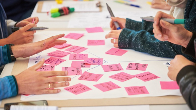 Cilvēki raksta uz līmlapiņām