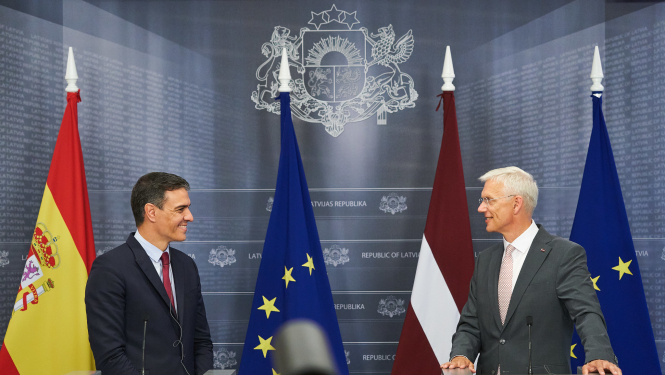 Spānijas premjerministrs Pedro Sančess un Latvijas premjerministrs Krišjānis Kariņš, fonā Eiropas Savienības un abu valstu karogi