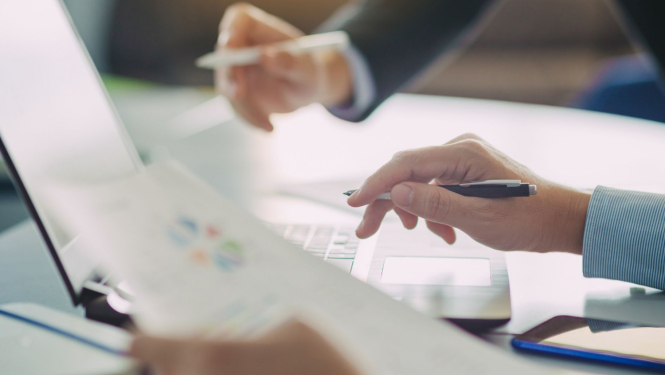 Cilvēki rēķina uz kalkulatora, rokā dokumenti