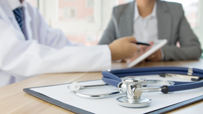 Ārsts un pacients. Uz galda stetoskops. 