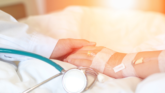 Ārsts tur pacienta roku.