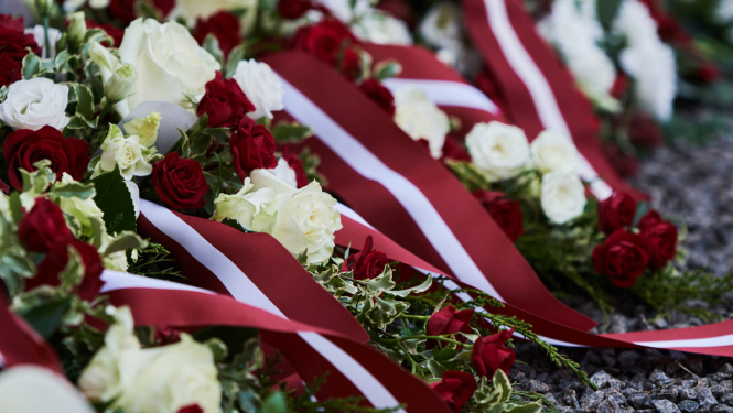 Sarkani un balti ziedi ar sarkanbaltsarkanām karoga lentēm