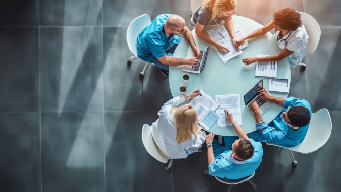 Attēls ar ārstiem, kas sēž pie vienota galda