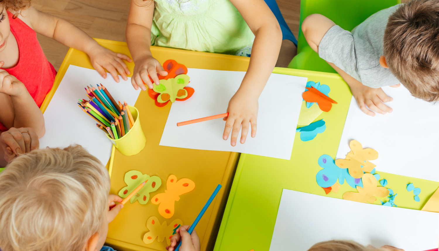 Foto ar bērnudāza galdu attēlojumu un bērnu rokdarbiem