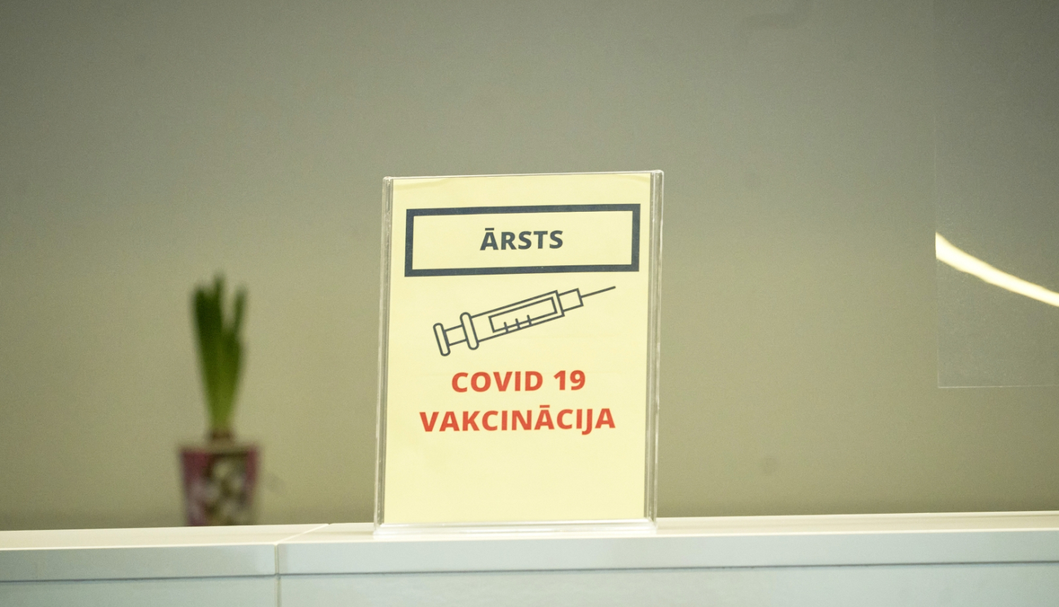 attēls ar šļirci un uzrakstu Covid-19 vakcinācija