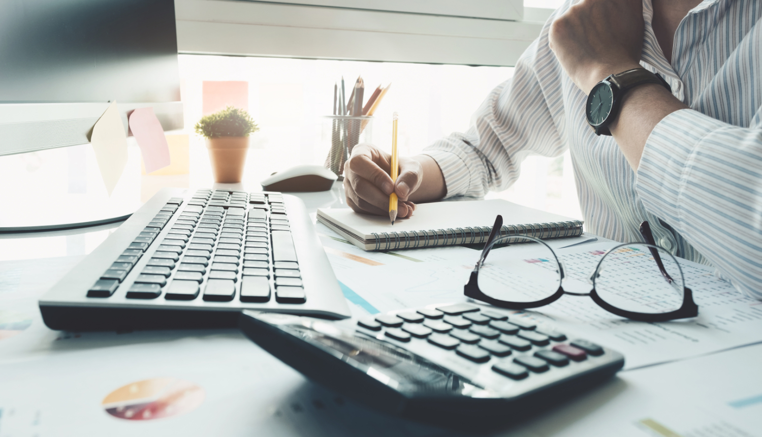 Fondu aprēķināšana, divi kalkulatori, lapas ar gafikiem un domājošs vīrietis