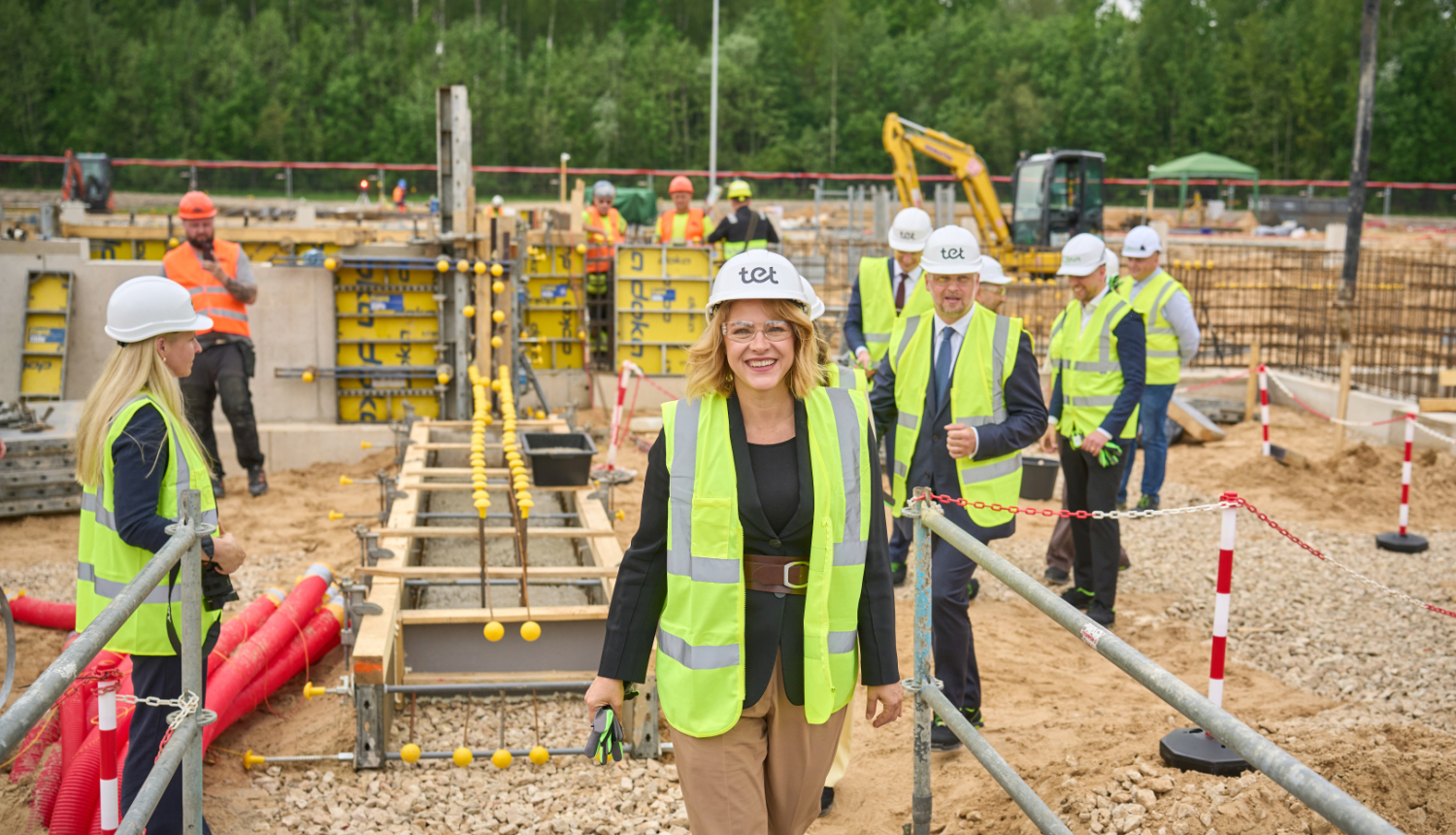 Ministru prezidente Evika Siliņa piedalās kapsulas iemūrēšanā. Ministru prezidente ģērbusies atstarojošā vestē un ar aizsargķiveri galvā atrodas būvlaukumā.