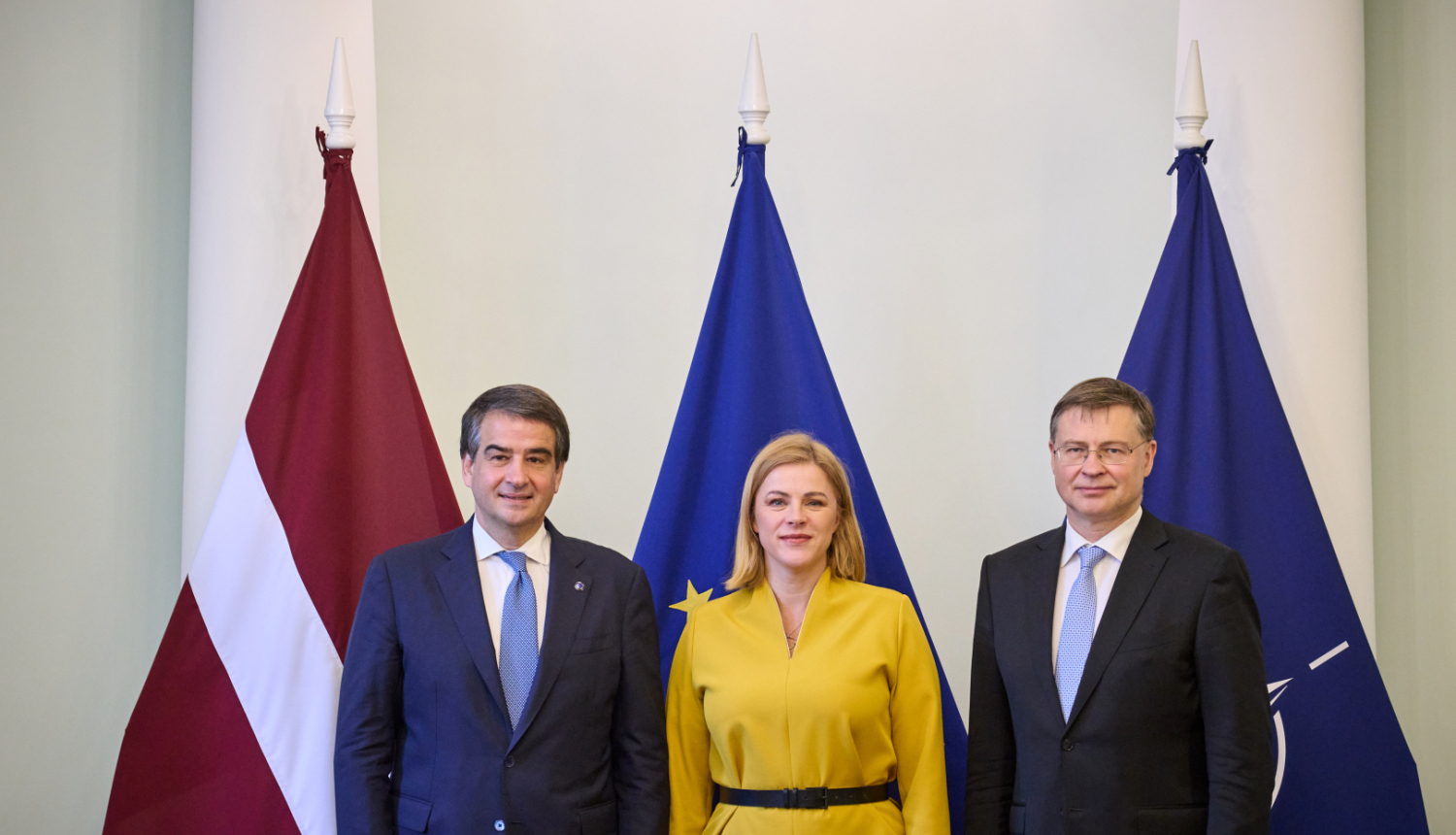 Fotogrāfijā pie Latvijas, Eiropas Savienības, NATO karogiem no labās Eiropas Komisijas priekšsēdētājas izpildvietnieks kohēzijas un reformu jautājumos Rafaēle Fito, Ministru prezidente Evika Siliņa, Eiropas Komisijas priekšsēdētājas izpildvietnieks jautājumos par ekonomiku Valdis Dombrovskis