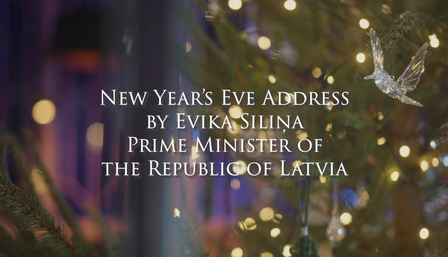 Text New Year's Eve Address by Evika Siliņa Prime Minister of the Republic of Latvia, lights in the branches of a Christmas tree in the background