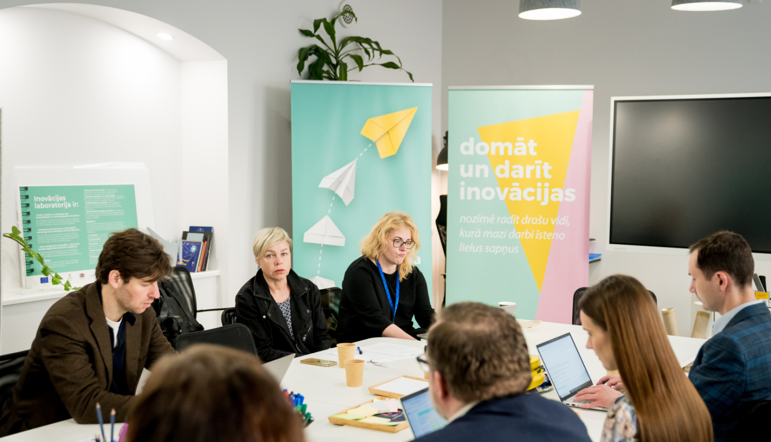 Inovāciju sprints - dalībnieki sēž pie galda, sarunājas